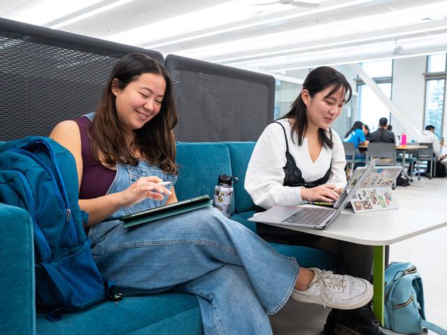 Two UC Davis students work side-by-side inside one of the study booths in the Teaching and Learning Complex
